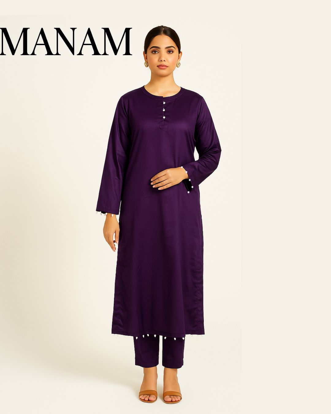Woman wearing a casual pearl detailed  deep plum shirt with trouser  a white background, branded 'Manam'.
