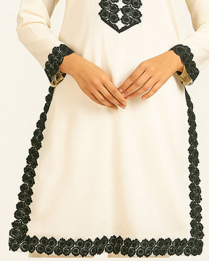 Person wearing a white dress with black floral lace embroidery sleeves style.